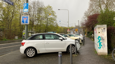 Parkende Autos beanspruchen den gesamten Platz seitlich der Straße