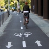Radfahrer auf Zweirichtungsradweg neben Straße – vergrößerte Ansicht wird in Lightbox angezeigt
