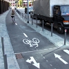 Radfahrer auf Zweirichtungsradweg mit Radwegmarkierungen neben Straße – vergrößerte Ansicht wird in Lightbox angezeigt