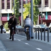 Zwei Radfahrer auf Zweirichtungsradweg neben Straße – vergrößerte Ansicht wird in Lightbox angezeigt